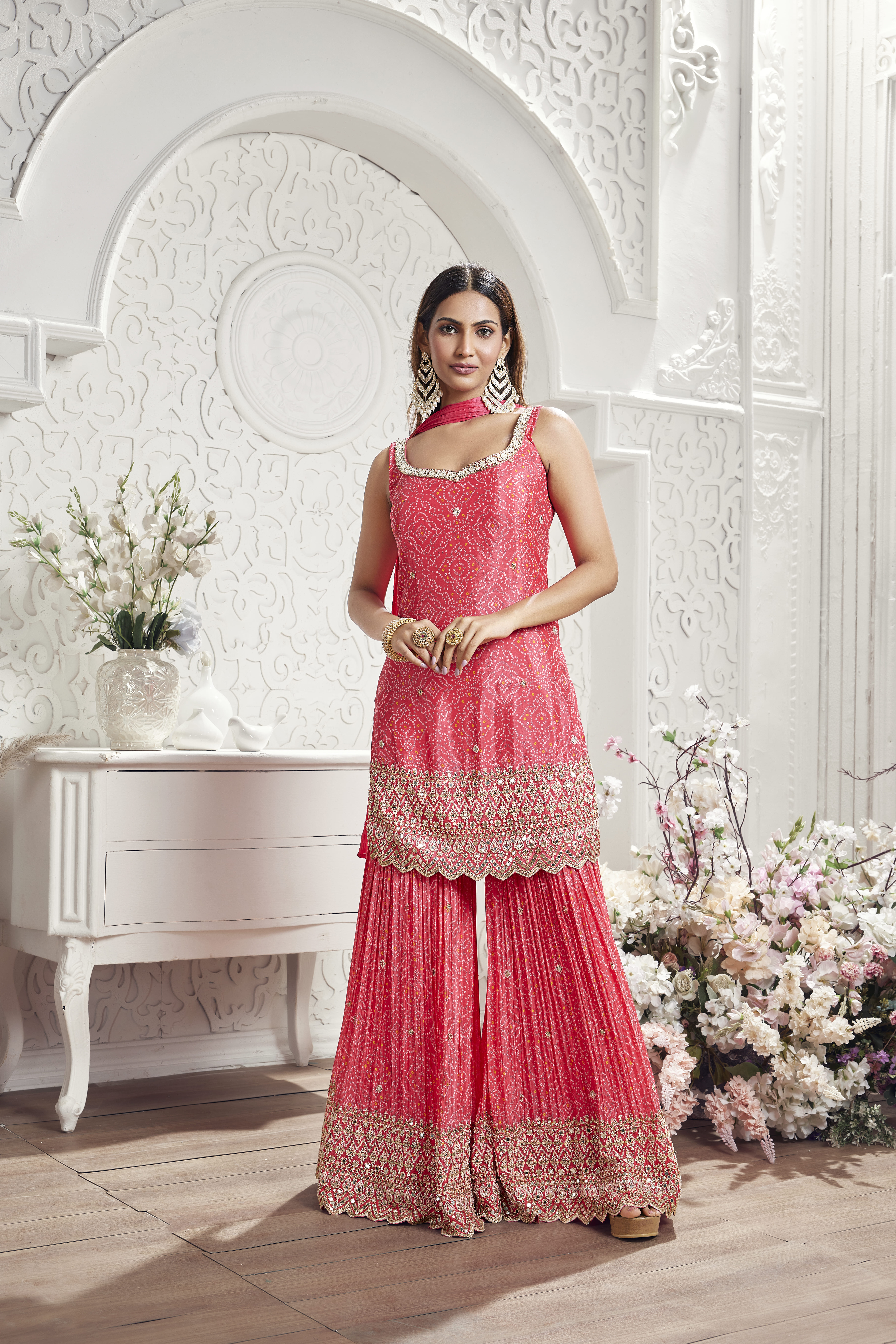Woman wearing rani pink embroidered kurta with pleated sharara and dupatta, traditional ethnic outfit with festive styling