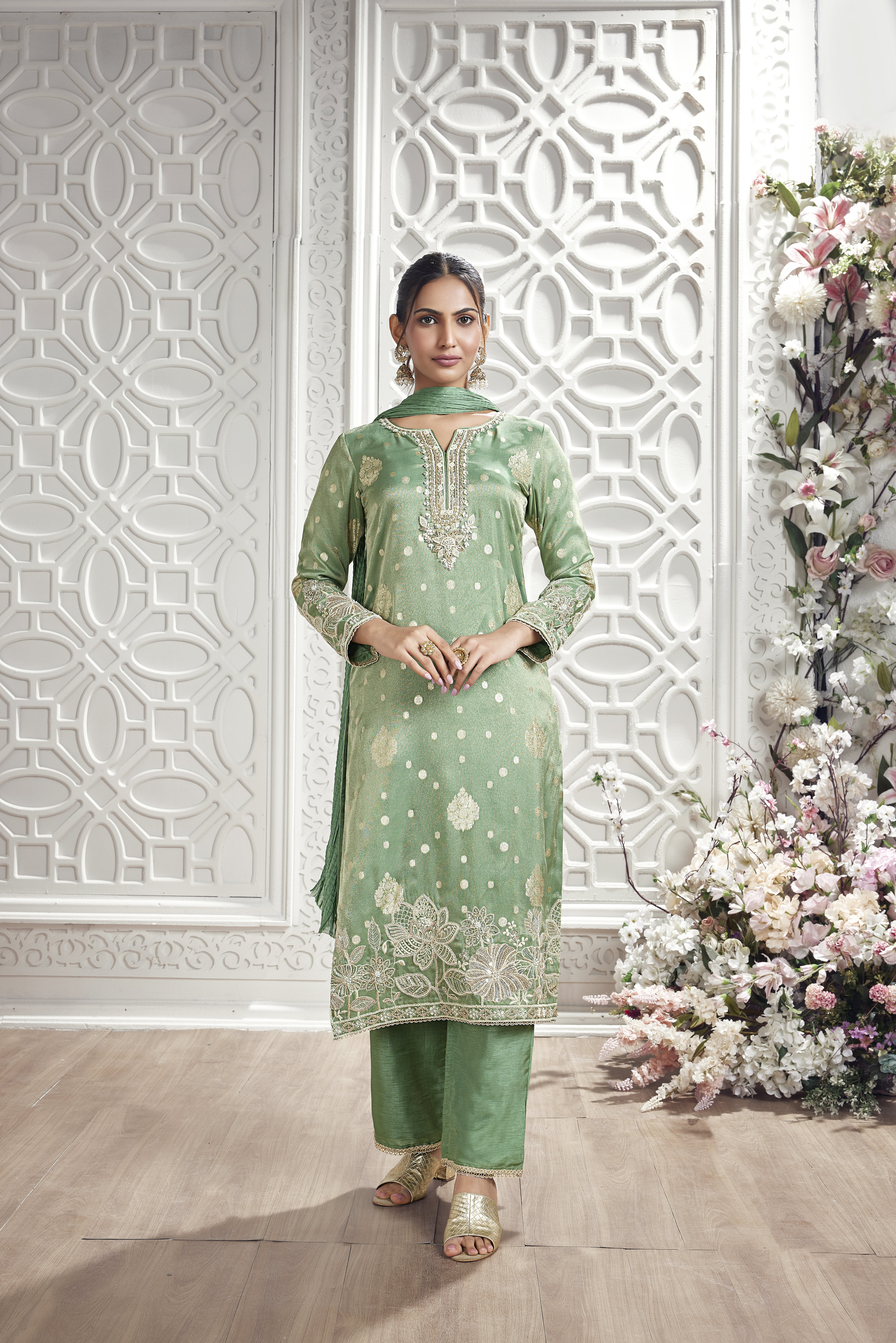 Woman wearing mint green embroidered silk kurta set with matching palazzo pants and dupatta.