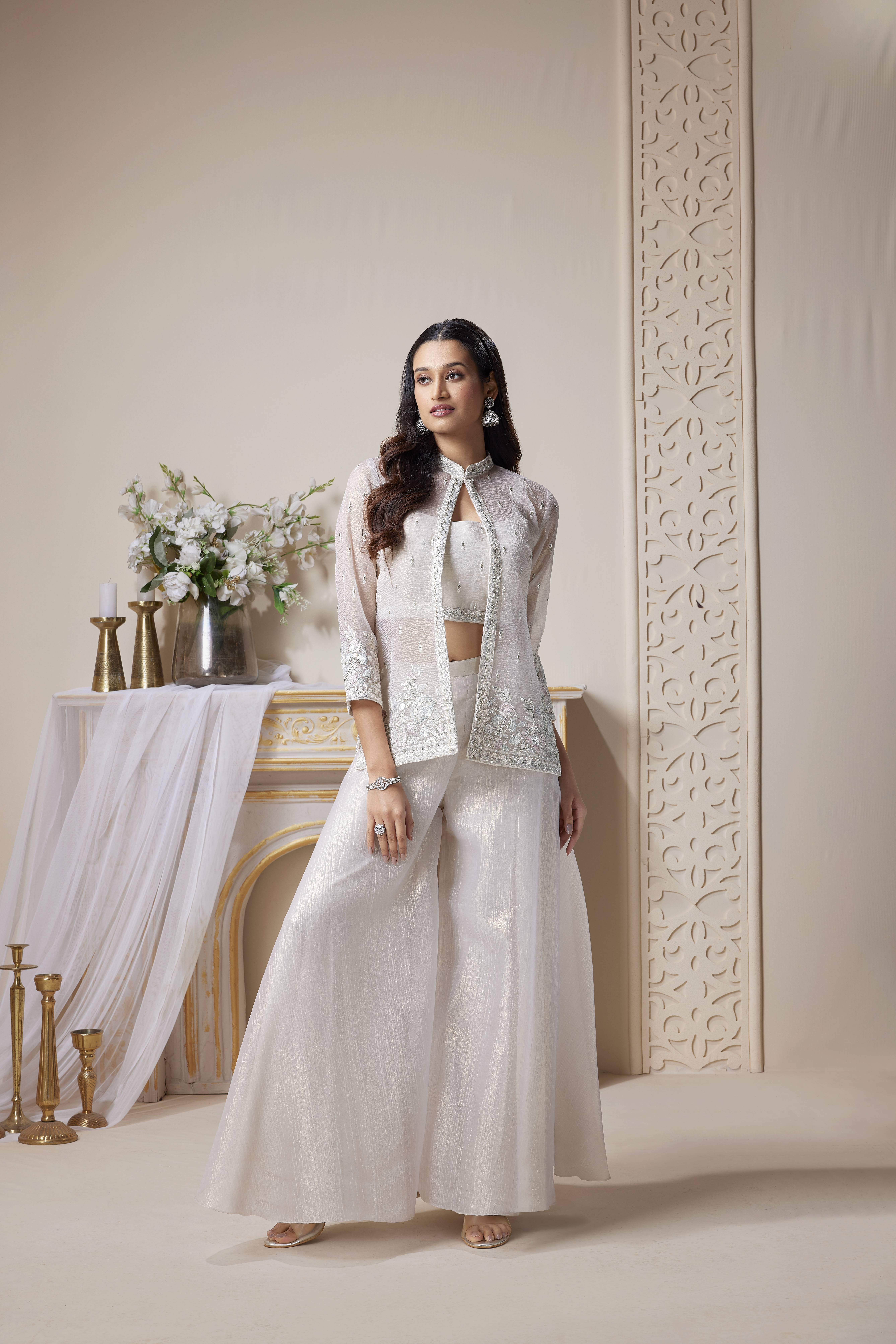 Woman wearing ivory co-ord set with embroidered sheer jacket, crop top and wide-leg pants, modern ethnic outfit