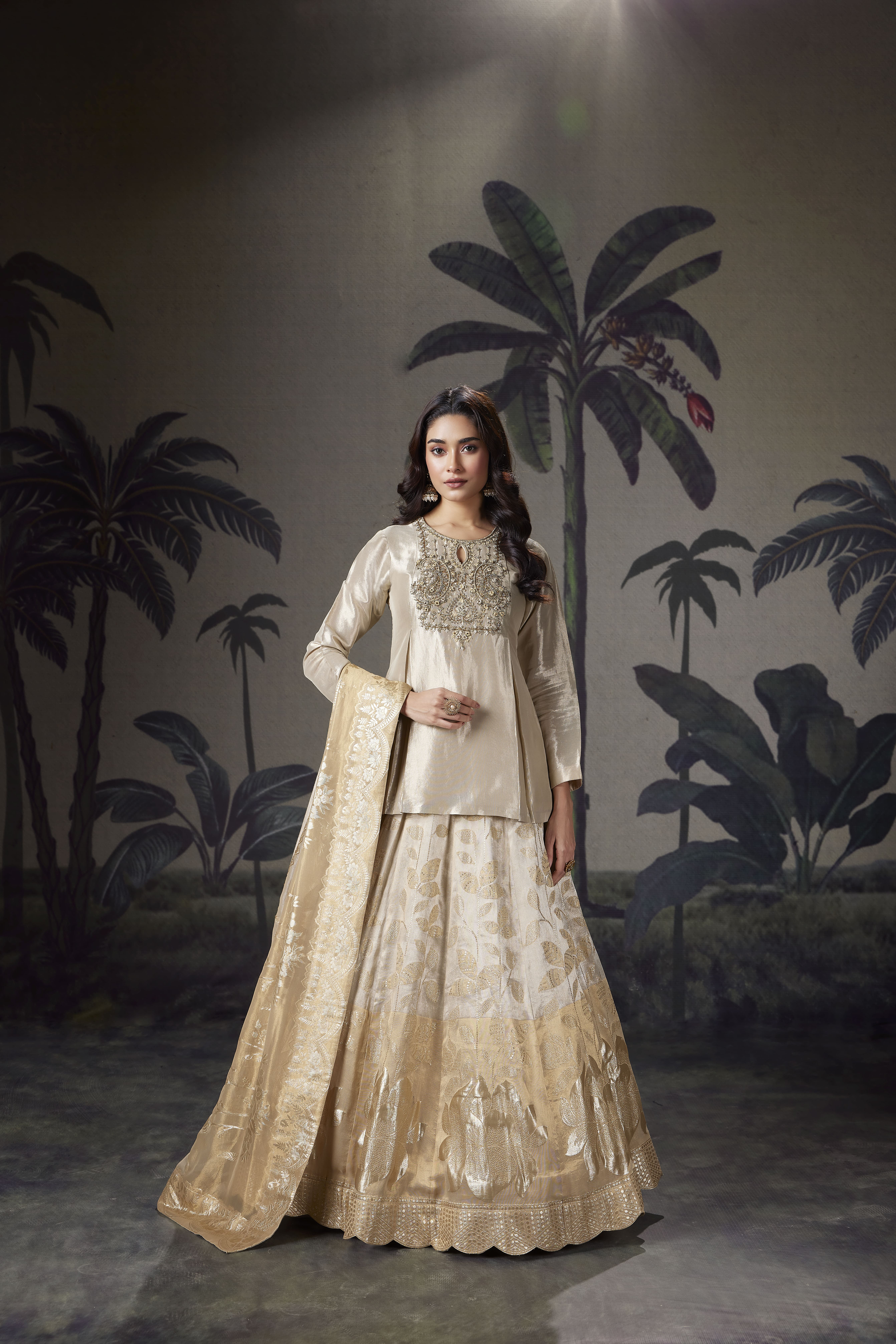 Woman wearing ivory gold embroidered kurta with Banarasi lehenga and dupatta, elegant traditional outfit with festive wedding styling