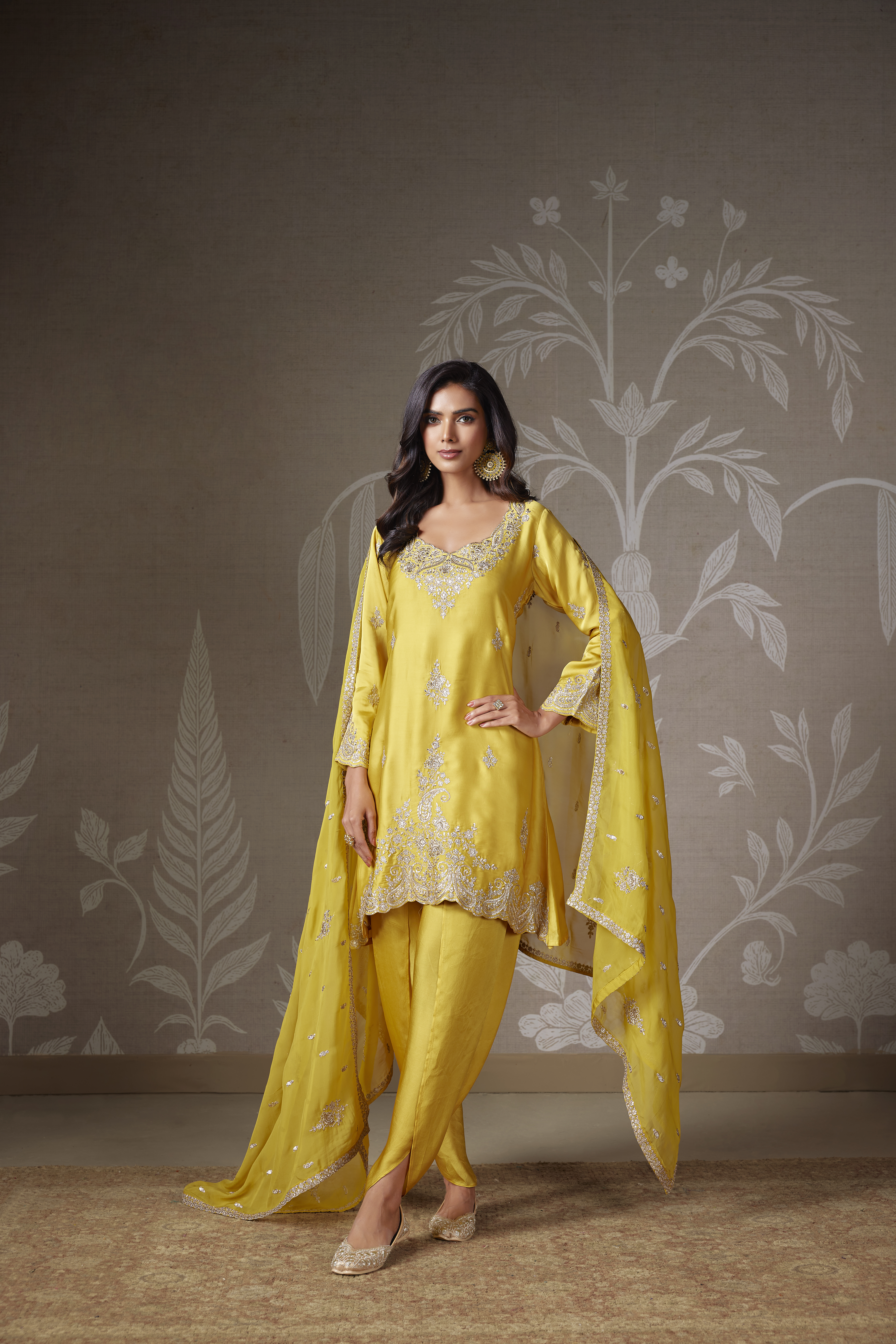 Woman wearing a sunshine yellow embroidered silk kurta set with tulip pants and embellished dupatta.