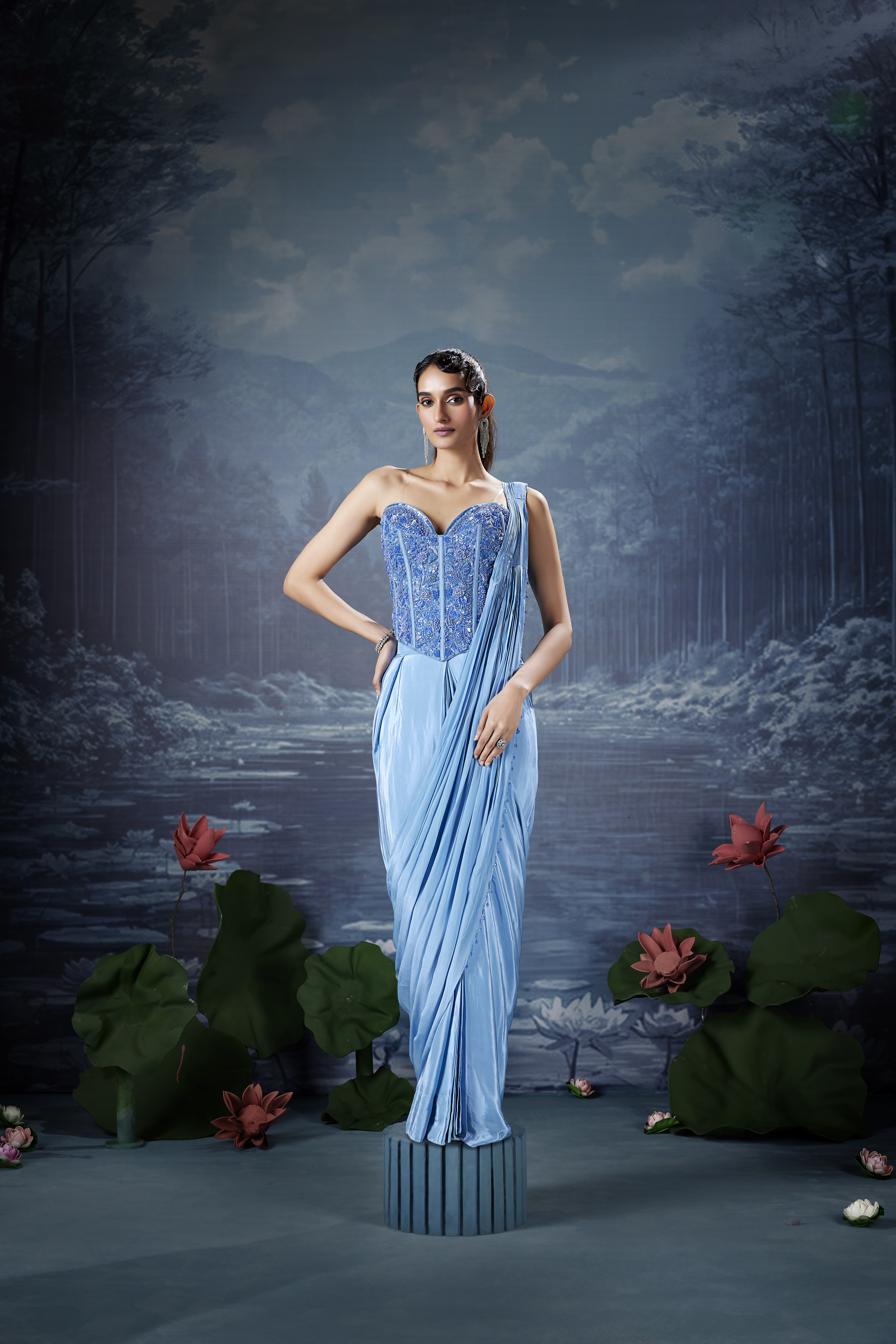 Woman wearing icy blue designer saree with corset embroidered blouse, elegant modern saree look with pastel tone and evening styling