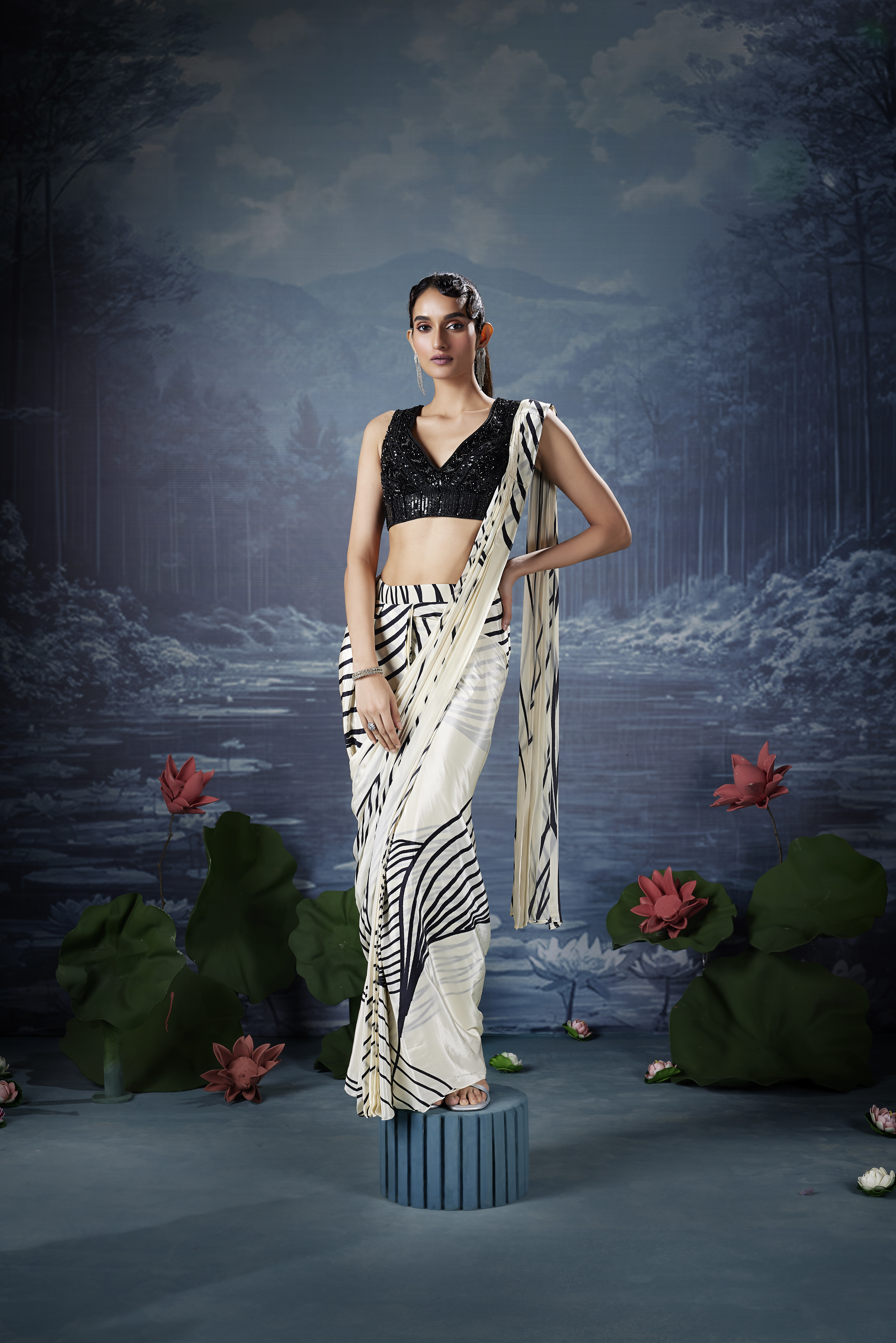 Woman wearing ivory and black printed saree with black sequin blouse, modern monochrome saree look with abstract design and evening styling