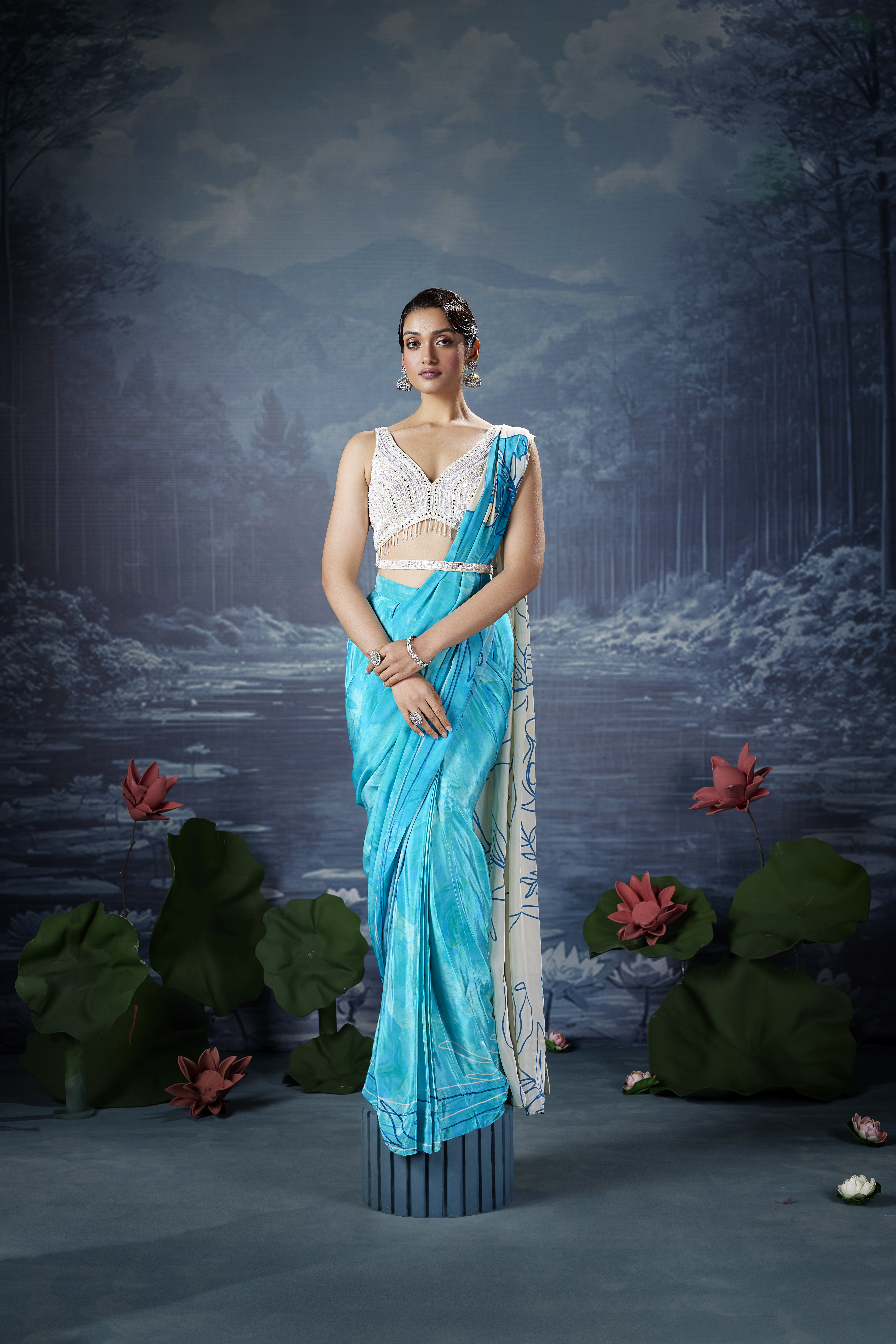 Woman wearing aqua blue designer saree with embellished blouse, elegant evening ethnic outfit with modern styling