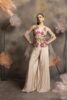 Woman wearing an ivory satin palazzo set with a sleeveless jacket featuring 3D floral embroidery in pink and orange, and a sheer organza dupatta, posing against a floral backdrop