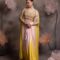 Woman wearing a blush pink to yellow ombre satin drape skirt with 3D floral embroidered bustier and matching cape, posing against a floral backdrop